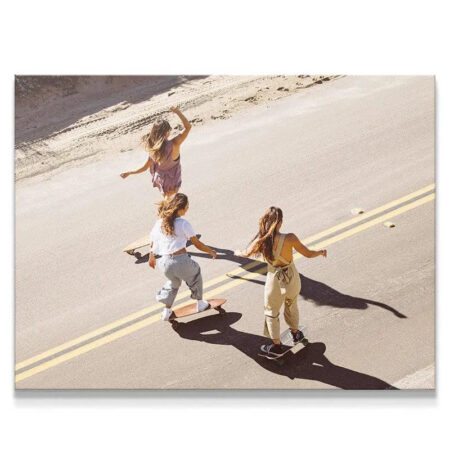 Aerial view of three girls enjoying a downhill longboard Skate session on asphalt.