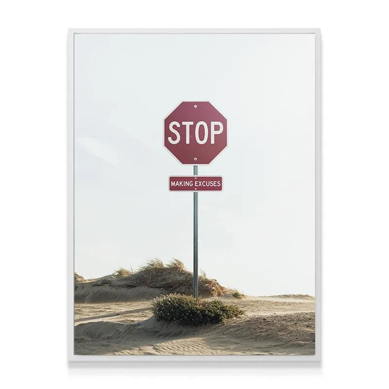 Framed canvas texture showcasing the crisp white typography on the deep red sign urging viewers to 'Stop Making Excuses' in a minimalist setting.
