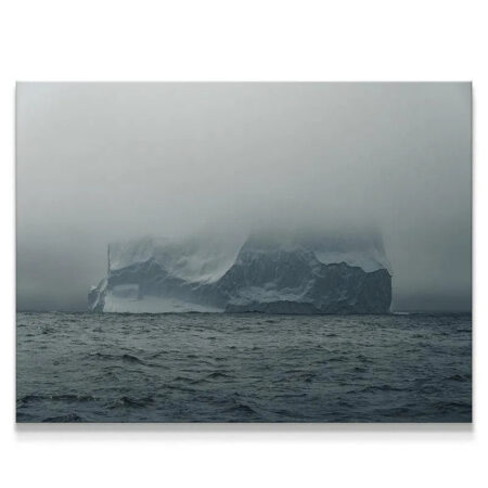 Wide-angle shot of the iceberg rising dramatically from dark waters, featuring The Arctic Walls Views.