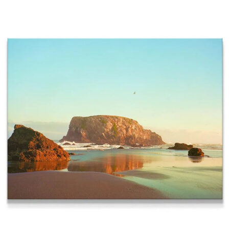 Wide scenic shot of Bandon beach landscape featuring the massive sea stack rock formations and the tiny silhouette of 'The Bird from Bandon'.