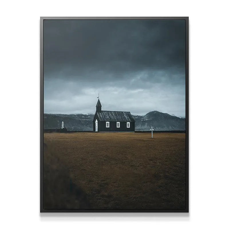 Landscape view of The Black Church showing the expansive brown field and distant snow-capped mountains.
