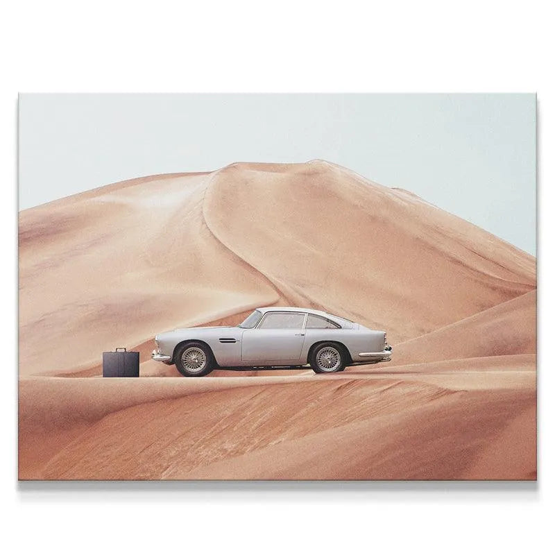 Wide shot of classic silver sports car and black briefcase against massive sand dunes captured in 'The Drop' print.
