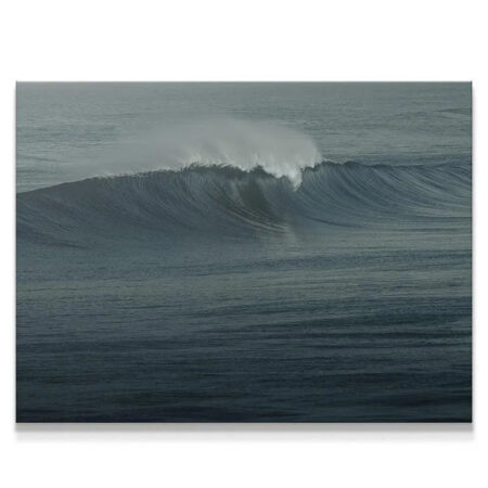 Close-up detail of the white foam spray crowning "The Glass Curl" in dark oceanic water.