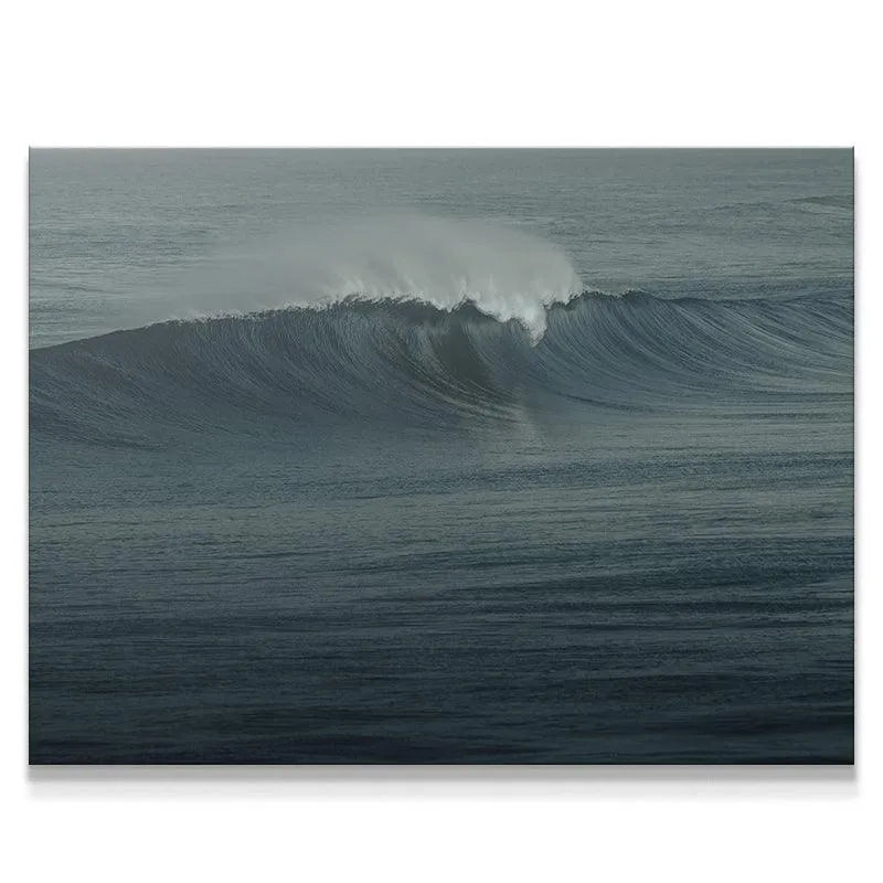 Close-up detail of the white foam spray crowning "The Glass Curl" in dark oceanic water.