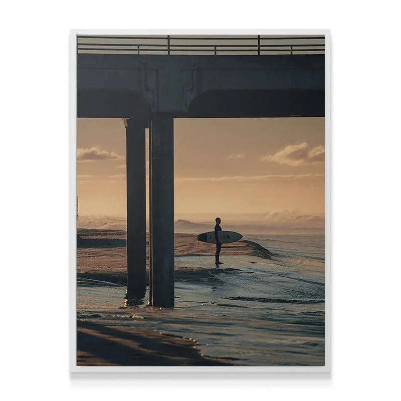 Detailed view of the lone figure holding the surfboard against the bright ocean backdrop in 'The Morning Wait'.