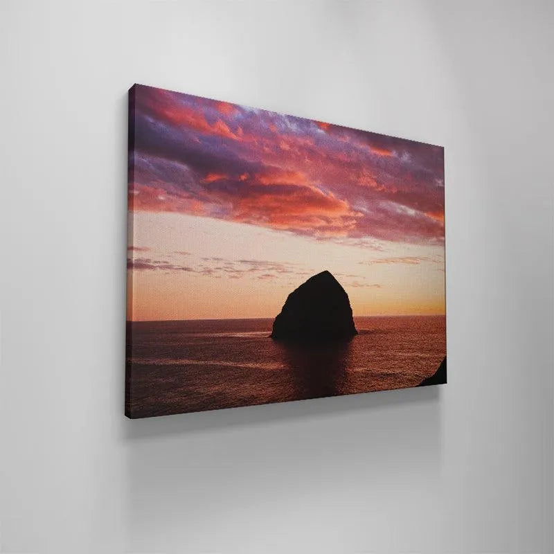 Panoramic landscape showing the entire horizon framing The Rock under heavy purple and orange clouds.