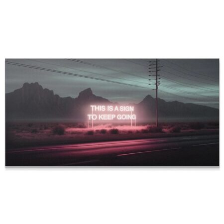 Close-up view of the glowing pink neon text reading "This Is A Sign To Keep Going."