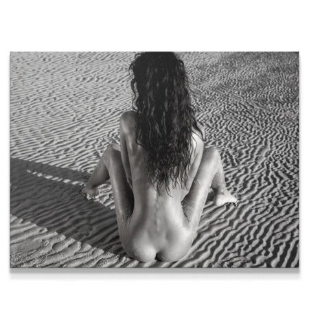 Full view of figure sitting on ribbed sand, evoking deep Thoughts.