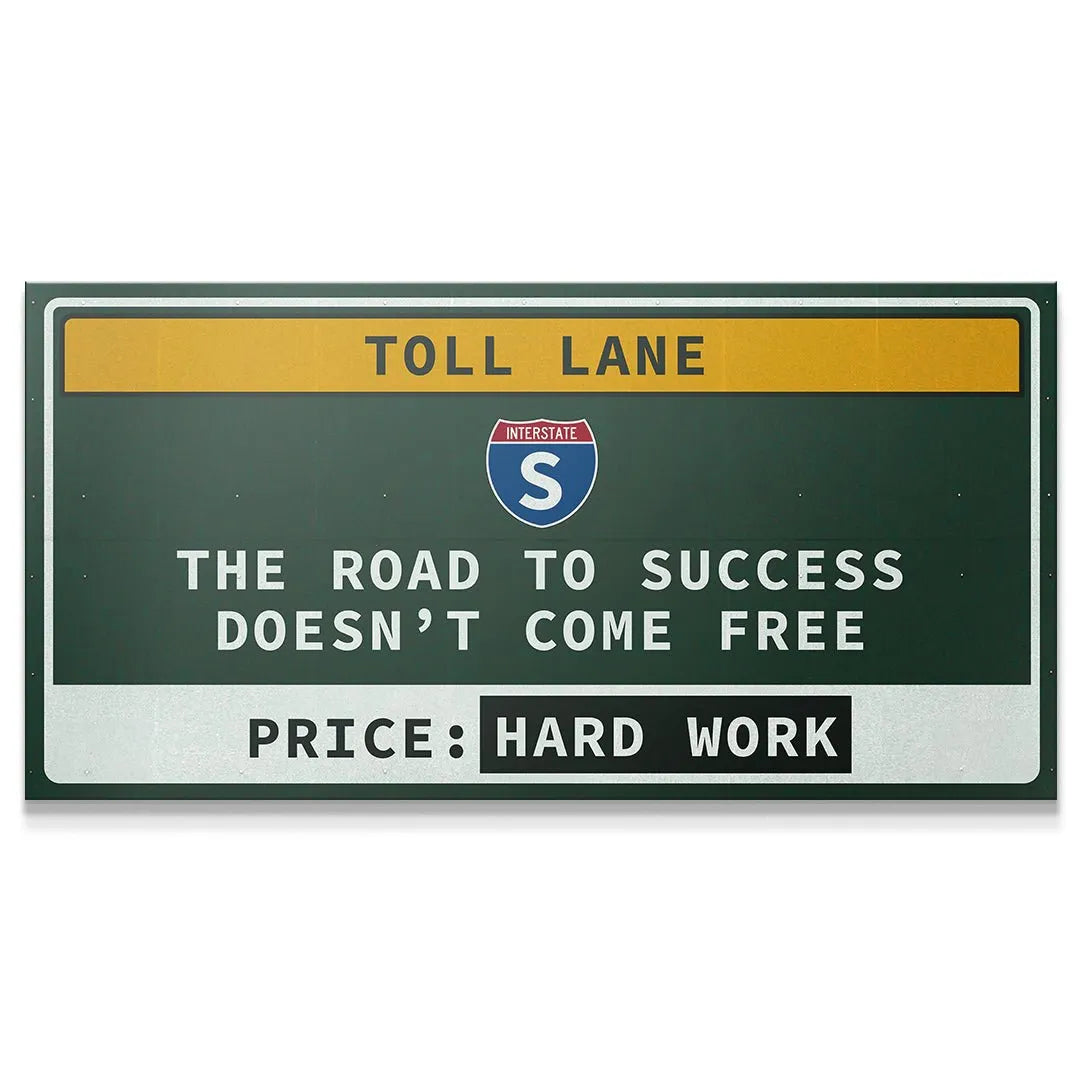 Full frontal view of the motivational Toll Lane metal sign hanging on a crisp white wall.